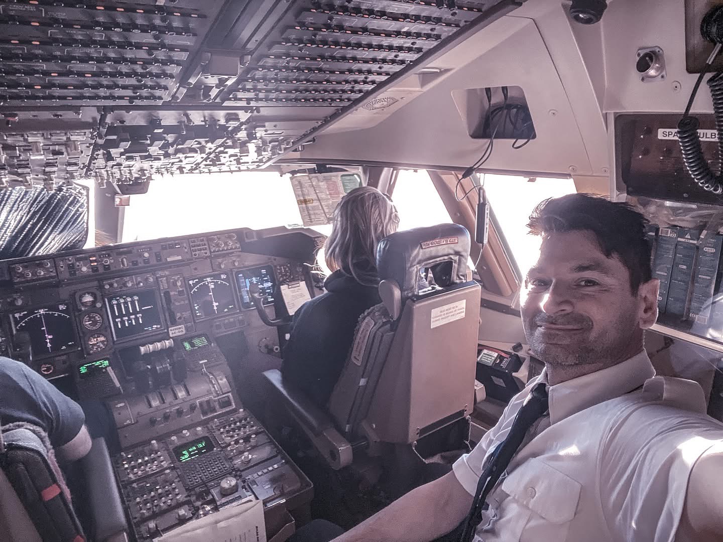 Alessio smiling in uniform on an airliner flight deck