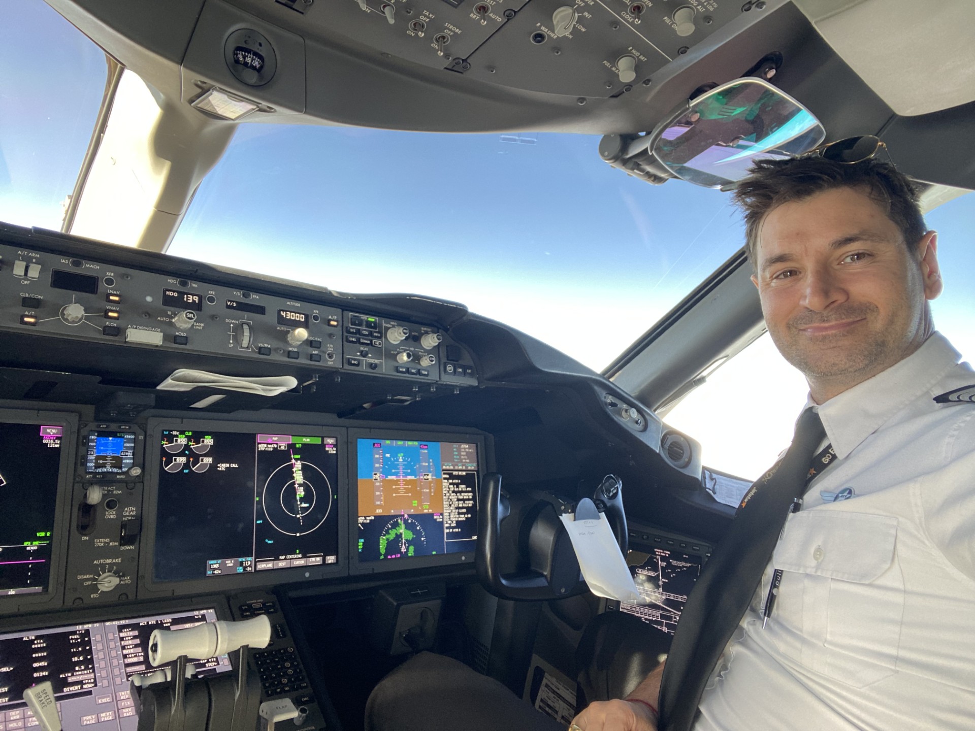 Alessio on the flight deck with blue skies beyond the windscreen