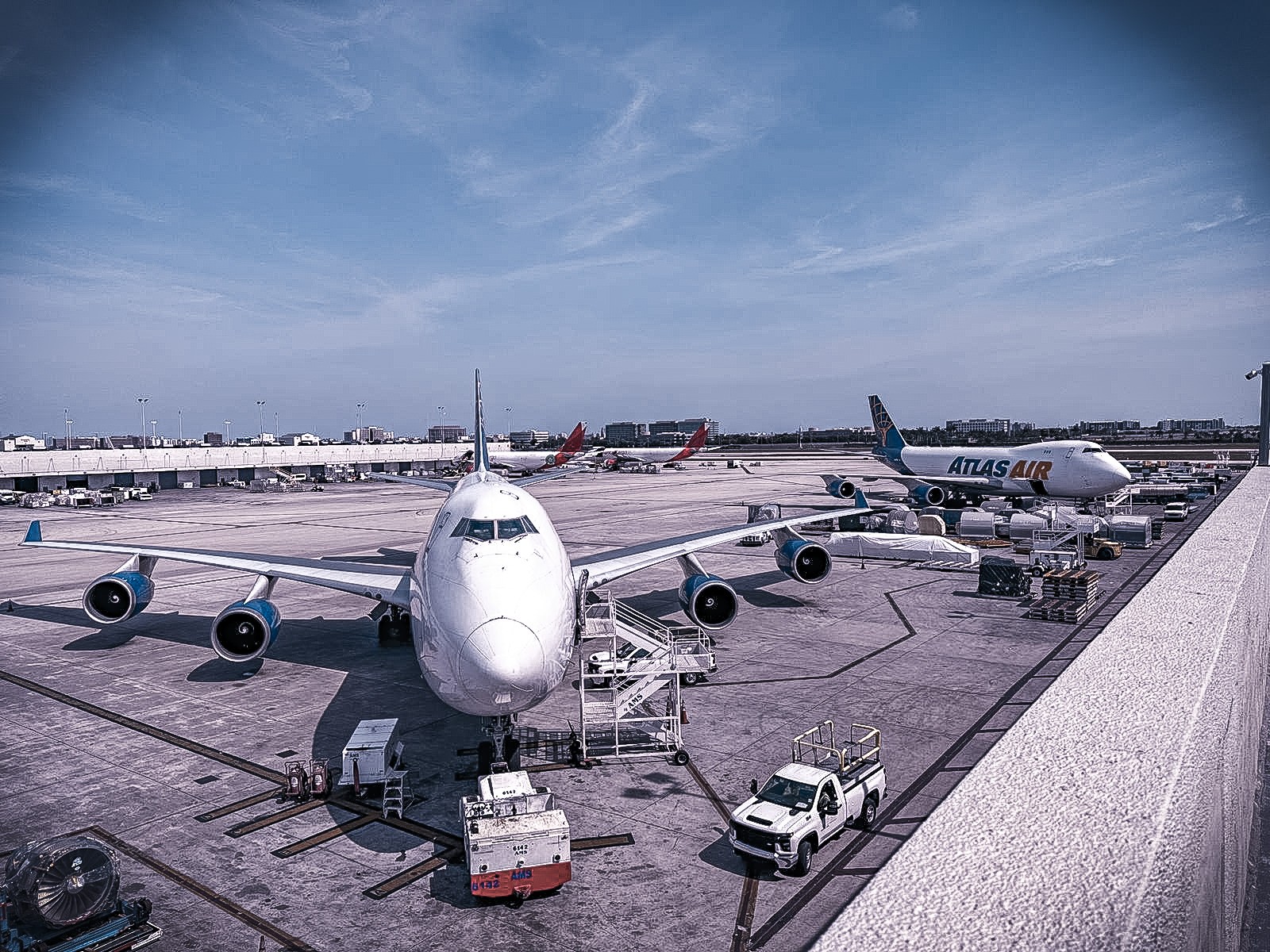 A Boeing 747 seen nose-on on a cargo apron, with an Atlas Air 747 in the background