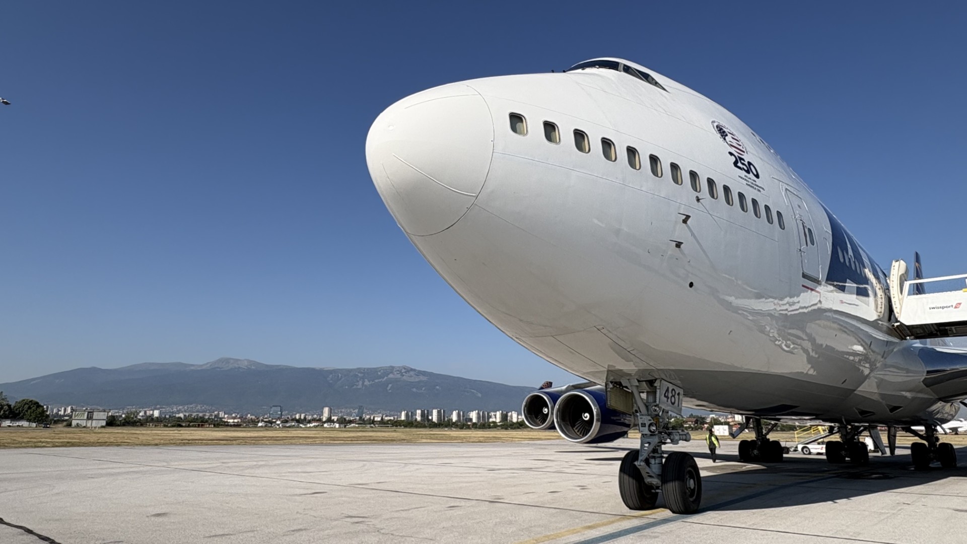 A close-up view of a Boeing 747 nose and landing gear on the apron