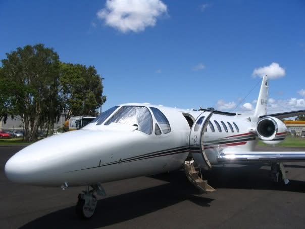 A small business jet parked on the apron