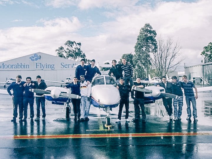 A group gathered around an aircraft outside Moorabbin Flying Services