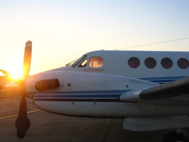Sunset light behind the propeller and nose of a turboprop